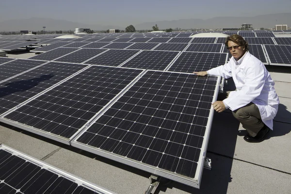 Trabalhador perto de painéis solares — Fotografia de Stock