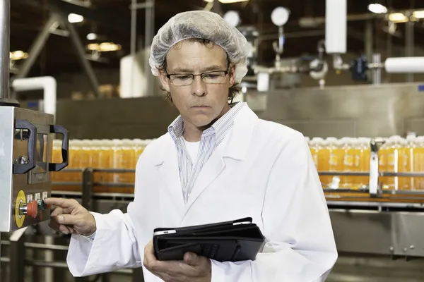 Hombre trabajando en la fábrica de embotellado — Foto de Stock