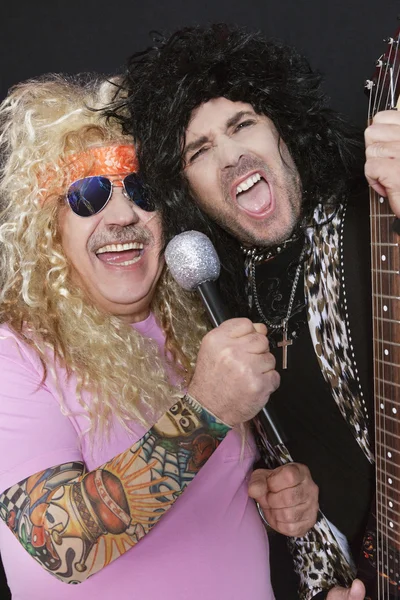 Two cheerful male friends singing and playing guitar — Stock Photo, Image