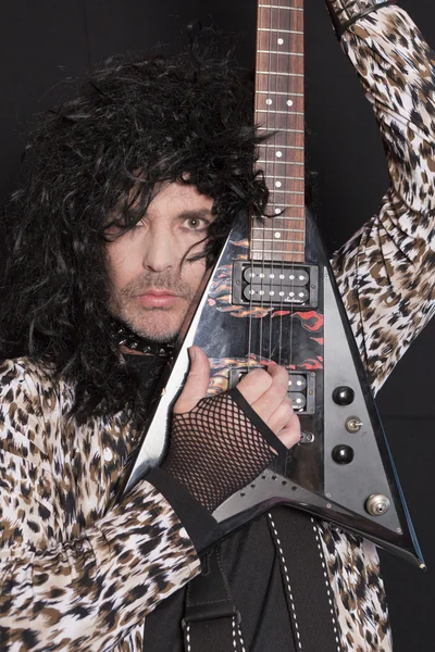 Retrato de homem de meia-idade vestindo padrão de pele de leopardo com guitarra elétrica — Fotografia de Stock