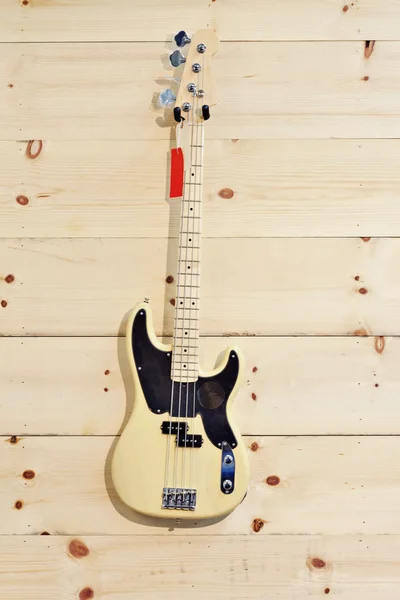 Akoestische gitaar met rode label op houtnerf muur — Stockfoto