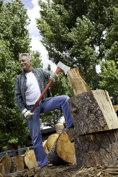 Senior man houdt een bijl — Stockfoto