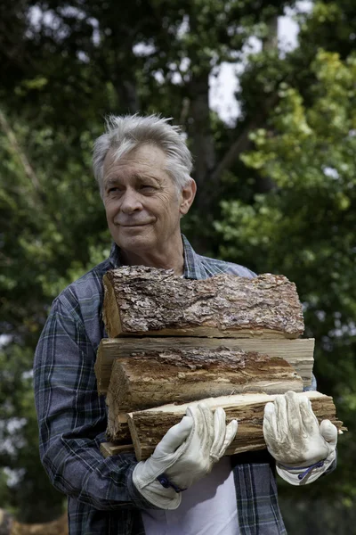 Senior man with firewood — Stock Photo, Image