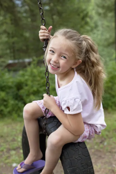 Girl swinging on tire — Stock Photo, Image