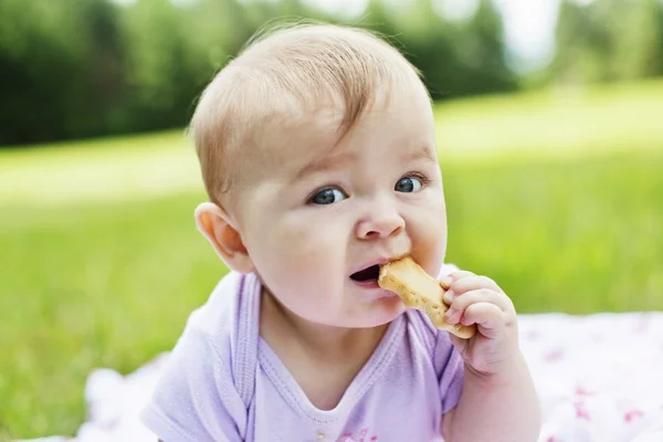 Close-up van baby meisje koekje eten — Stockfoto