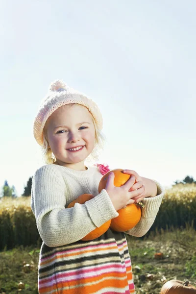 Retrato de una chica feliz sosteniendo calabazas — Foto de Stock