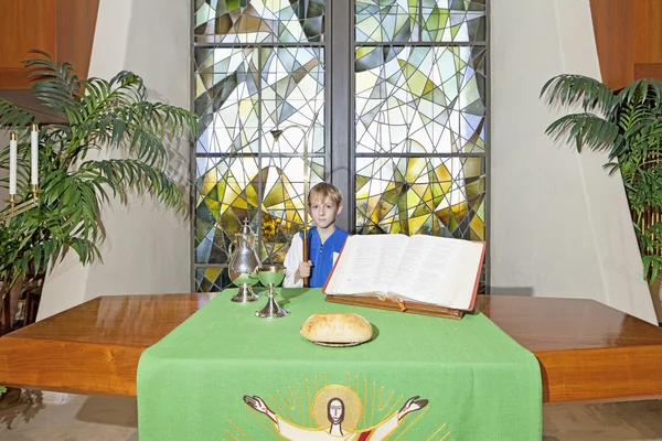 祭壇のテーブルのそばに立って小さな男の子 — ストック写真