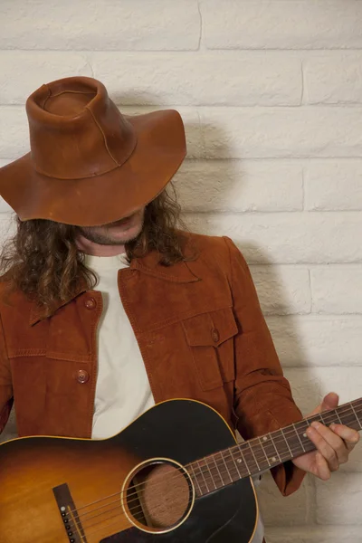 Mid adult man wearing cowboy hat and playing guitar — Stock Photo, Image