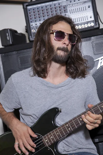 Jovem usando óculos de sol praticando com guitarra — Fotografia de Stock