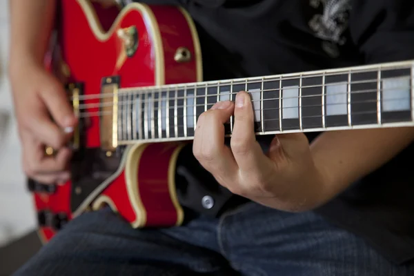 Närbild av unga kvinnans hand spelar gitarr — Stockfoto