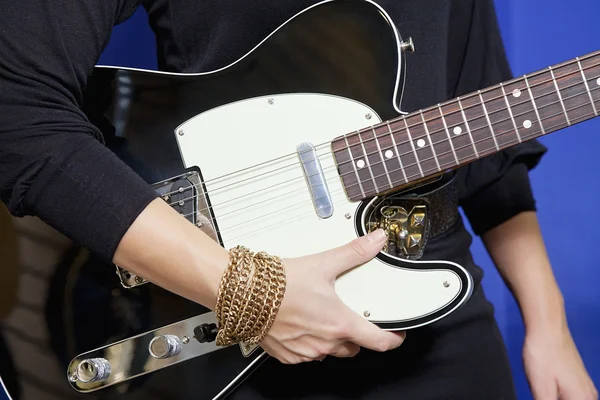 Midsection de mujer joven sosteniendo la guitarra eléctrica — Foto de Stock