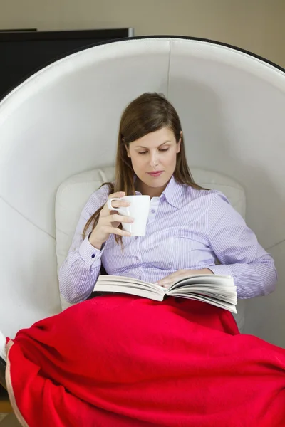 Mulher ler livro sentado em cadeira de ovo — Fotografia de Stock