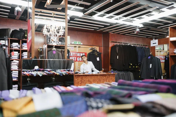 Hombre trabajando en una tienda de ropa — Foto de Stock