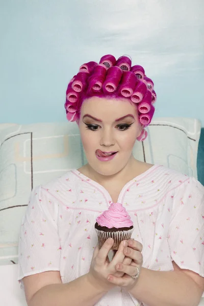 Verführte Frau schaut auf Cupcake — Stockfoto
