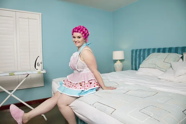 Young curvy woman sitting on bed — Stock Photo, Image