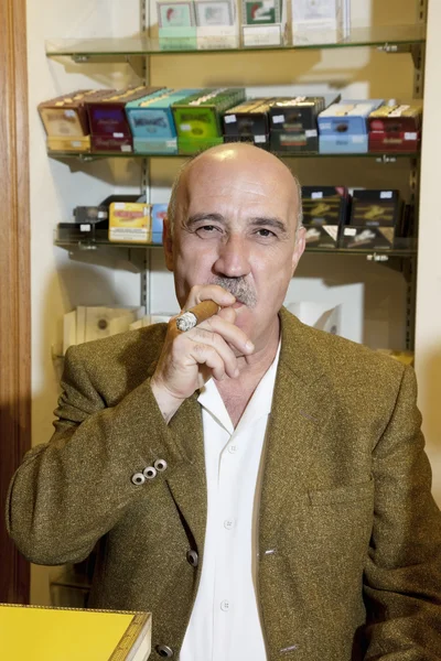 Retrato del dueño maduro de la tienda de tabaco fumando cigarro —  Fotos de Stock