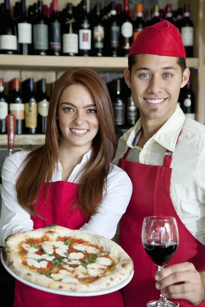 Retrato de un joven camarero con copa de vino y pizza —  Fotos de Stock