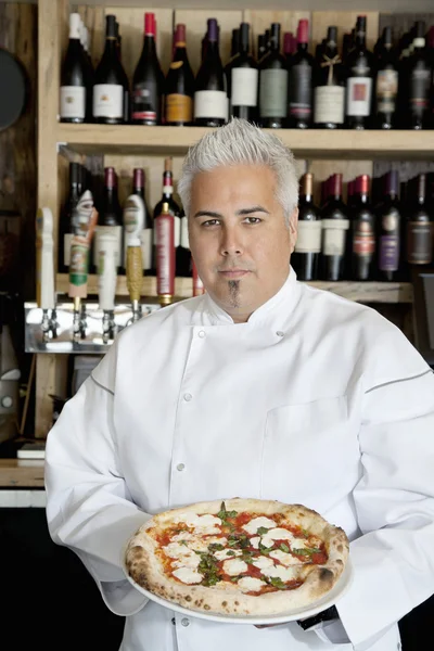 Portrait of a confident chef with pizza — Stock Photo, Image
