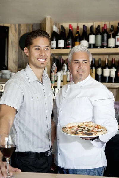 Happy men with wine glass and pizza looking away — Stock Photo, Image