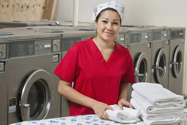 Portret van een Spaanse vrouwelijke werknemer met handdoek in wasserette — Stockfoto