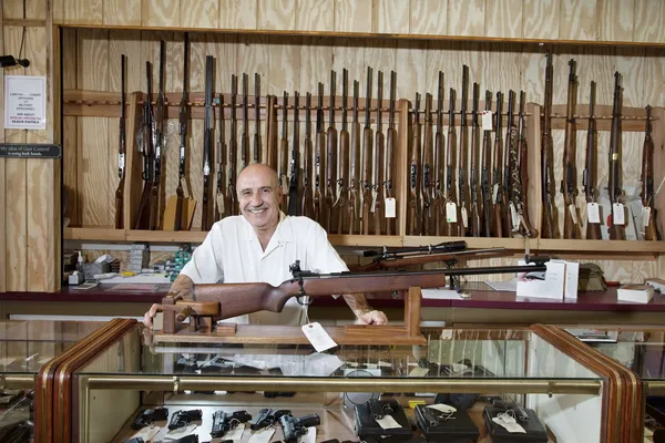 Retrato de um feliz dono de uma loja de armas — Fotografia de Stock