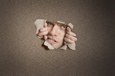 agresif orta sökük beyaz kağıt deliğinden dikizlerken yetişkin adam portresi