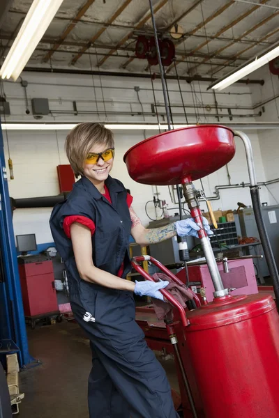 Porträt einer glücklichen Mechanikerin, die in der Garage an Schweißgeräten arbeitet — Stockfoto