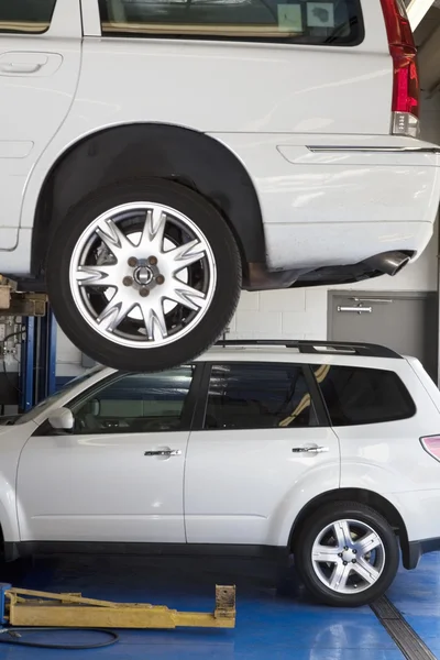 Car on hoist in automobile repair shop — Stock Photo, Image