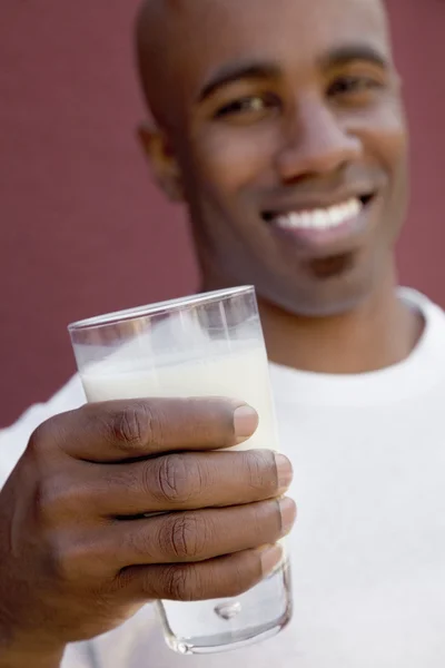 Närbild av ung man håller mjölk glas — Stockfoto