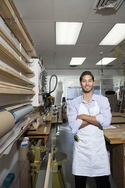 Retrato de un trabajador calificado feliz de pie con los brazos cruzados en el taller —  Fotos de Stock