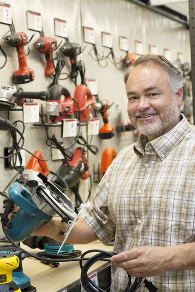 Portrait d'un heureux propriétaire de quincaillerie avec scie électrique — Photo