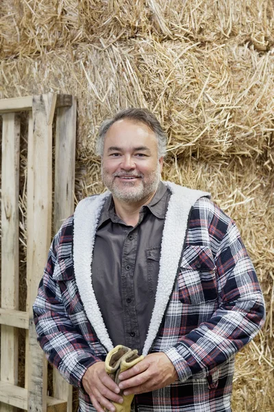 Portret van een gelukkig volwassen man voor hooi stapel — Stockfoto