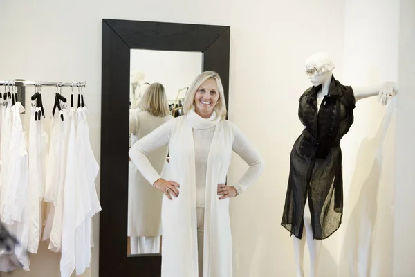Retrato de una mujer mayor feliz probándose la ropa en la boutique de moda — Foto de Stock