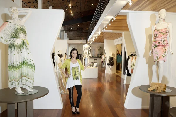 Ritratto di una bella donna adulta in piedi con manichini nella boutique di moda — Foto Stock