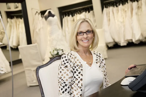 Portret van een gelukkig senior vrouw dragen brillen zitten in bruids winkel — Stockfoto