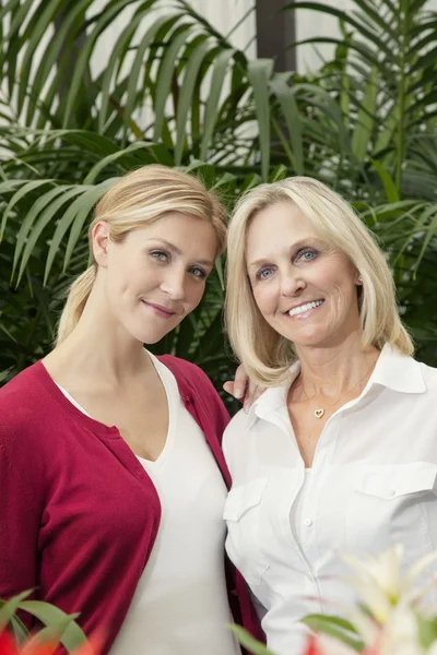 Portret van gelukkige moeder en dochter in kas — Stockfoto