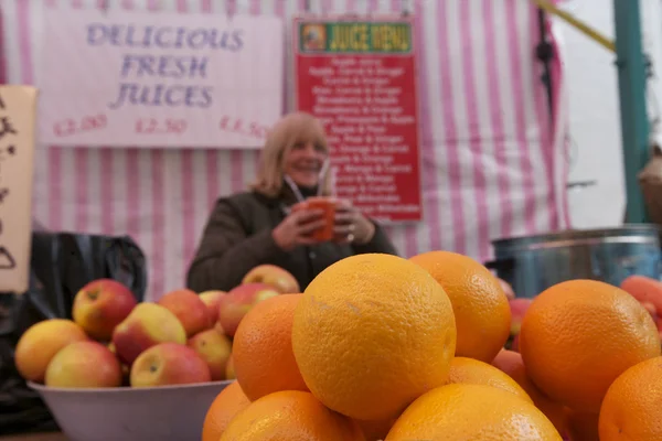 Close-up of oranges on display with senior owner in background — Stock Photo, Image