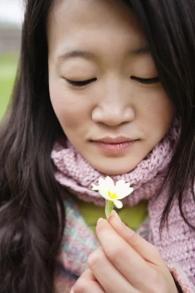 花を見て若いアジアの女性のクローズ アップ — ストック写真