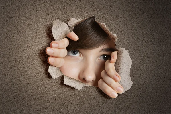 Middle eastern woman peeking from ripped white paper hole — Stock Photo, Image
