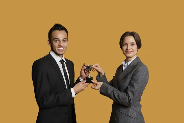 Retrato de socios felices sosteniendo trofeo ganador juntos — Foto de Stock