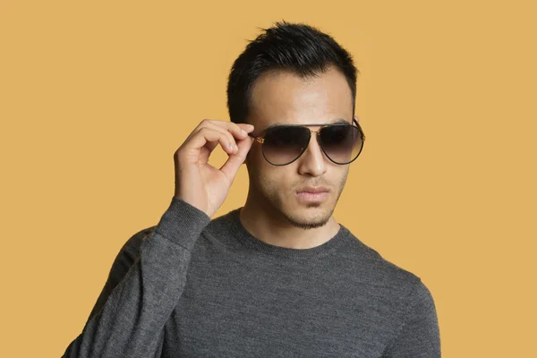 Elegantní mladý muž nosí sluneční brýle barevné pozadí — Stock fotografie