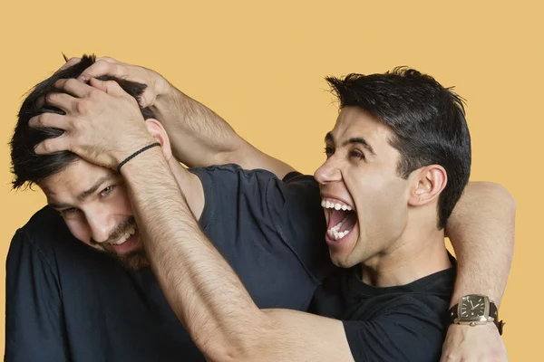 Joven macho amigos jugando peleas sobre fondo de color —  Fotos de Stock