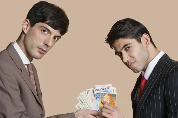 Porträtt av unga affärsmän visar euro över färgad bakgrund — Stockfoto