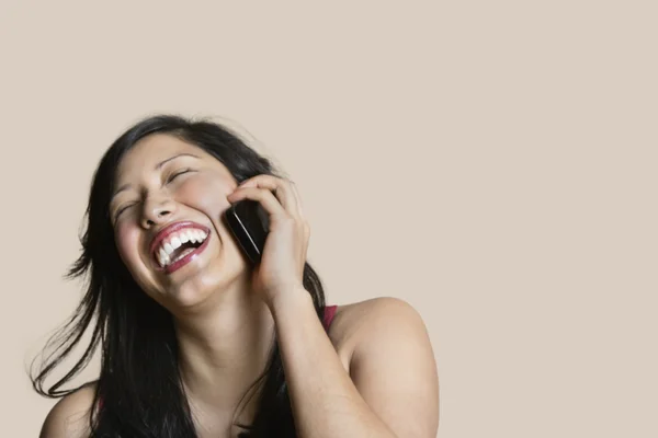 Vrolijke jonge vrouw praten op mobiele telefoon over gekleurde achtergrond — Stockfoto