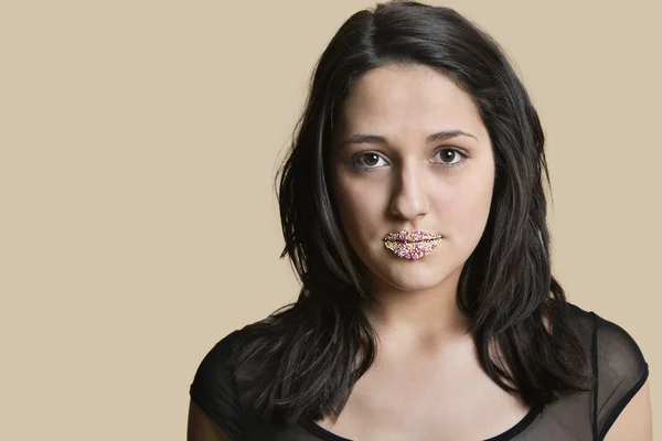 Portrait d'une belle jeune femme aux lèvres saupoudrées sur fond coloré — Photo