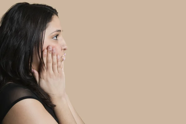 Zijaanzicht van jonge vrouw met bestrooid lippen op gekleurde achtergrond — Stockfoto