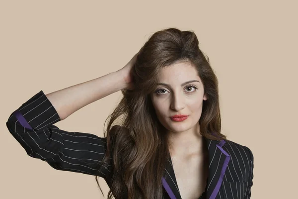Портрет красивой молодой женщины с рукой в волосах на цветном фоне — стоковое фото