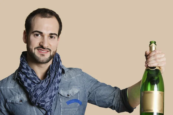 Porträt eines glücklichen jungen Mannes mit Champagner vor farbigem Hintergrund — Stockfoto