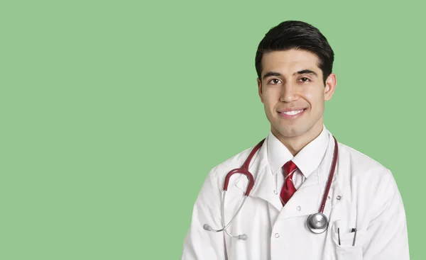 Retrato de un médico varón feliz con bata de laboratorio sobre fondo verde — Foto de Stock