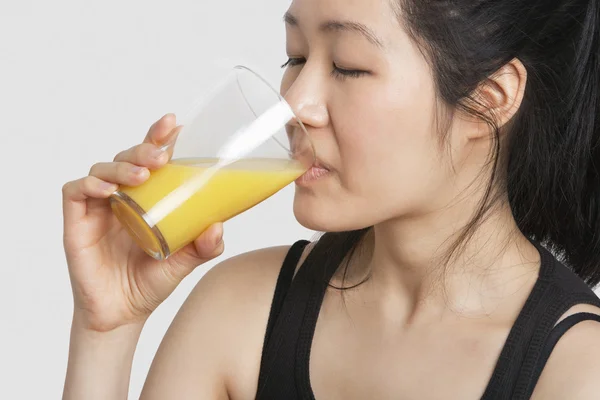 Vrouw die sinaasappelsap drinkt — Stockfoto